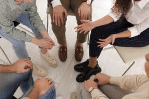 People sitting in a circle in a group therapy session.