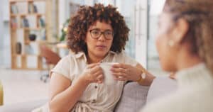 Two friends chatting in a serious conversation over coffee.