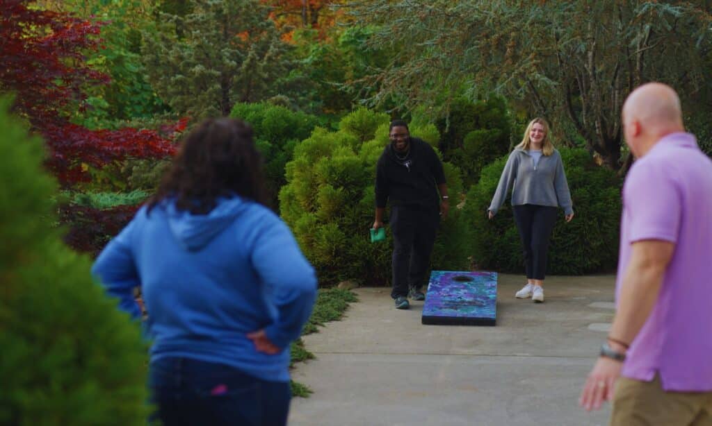 Pasadena Villa large section hero image - employees playing cornhole